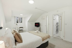 A bedroom with a bed, a TV, a desk, and a wardrobe. - Modern Ensuite Home with Drive and easy M6 Access (Wednesbury)