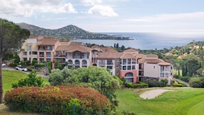 Ein Küstenhotel mit mehreren Gebäuden, Blick auf das Meer und einer hügeligen Landschaft.