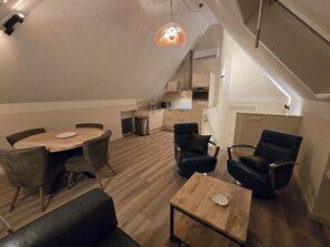 A modern loft apartment with a dining area, seating, a kitchen, and a staircase. - Vacation home "Heidezee" in Dishoek - Relaxed days, comfortable and close to the beach (Koudekerke)