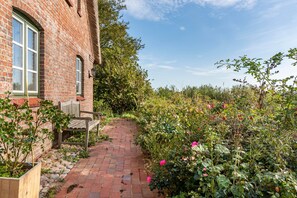 Un bâtiment en briques avec une fenêtre et un banc à l’extérieur.
