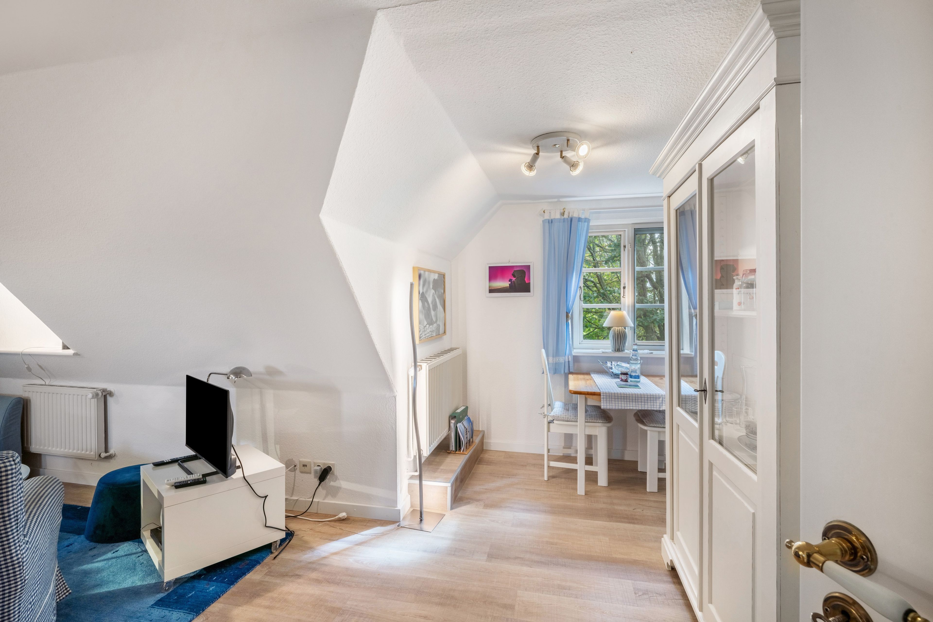 Ein Zimmer mit Schreibtisch, Stuhl und Heizkörper.