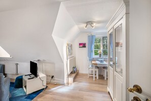 Une pièce avec un bureau, une chaise et un radiateur.