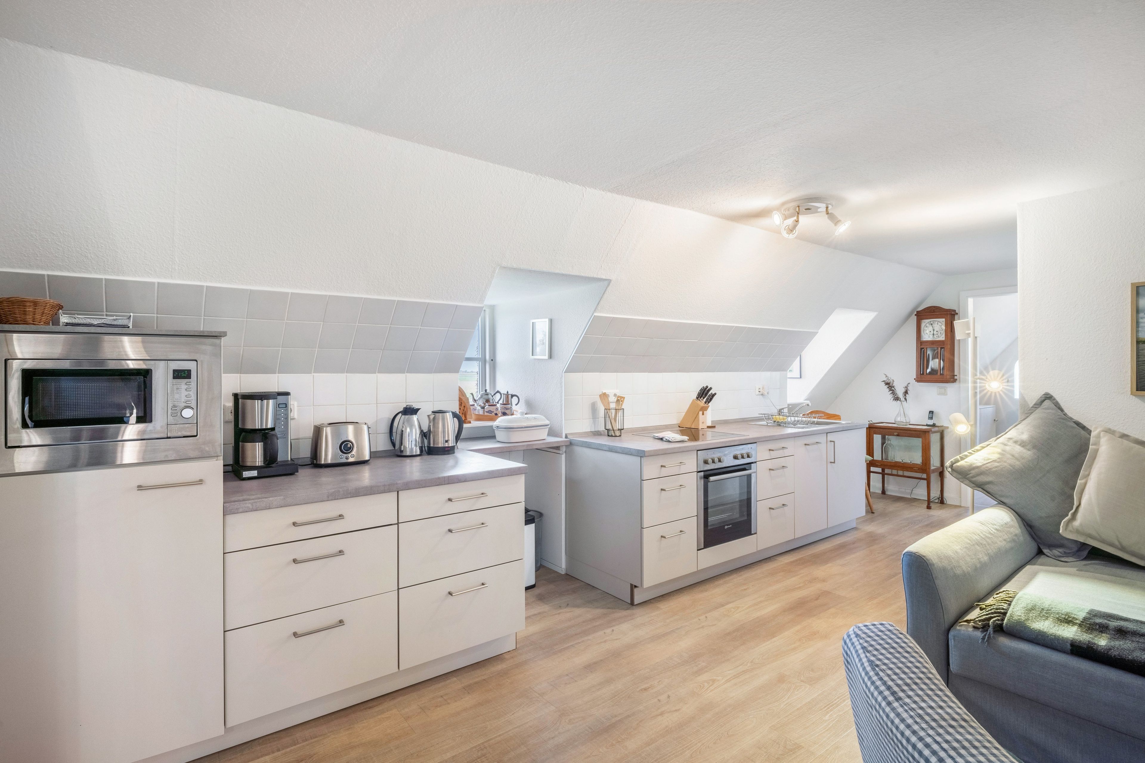 A modern kitchen with a built-in oven, microwave, and coffee maker.
