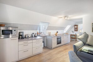 Een moderne keuken met een inbouwoven, magnetron en koffiezetapparaat.