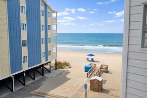Ein Strandhotel mit Poolbereich, Liegestühlen und Sonnenschirm.