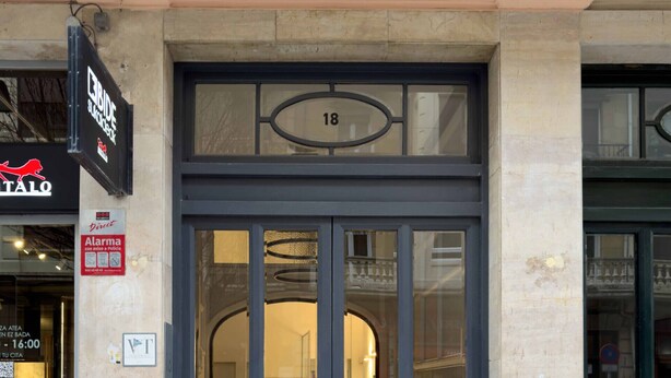 A building entrance with a large glass door marked with the number 18. - Usandizaga | The Rentals Collection (San Sebastián/Donostia)