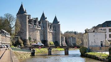 Un château historique doté de nombreuses tours, d’un pont et bordé par une rivière.