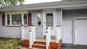 Une maison de plain-pied avec un porche à l’avant, un garage et une boîte aux lettres.