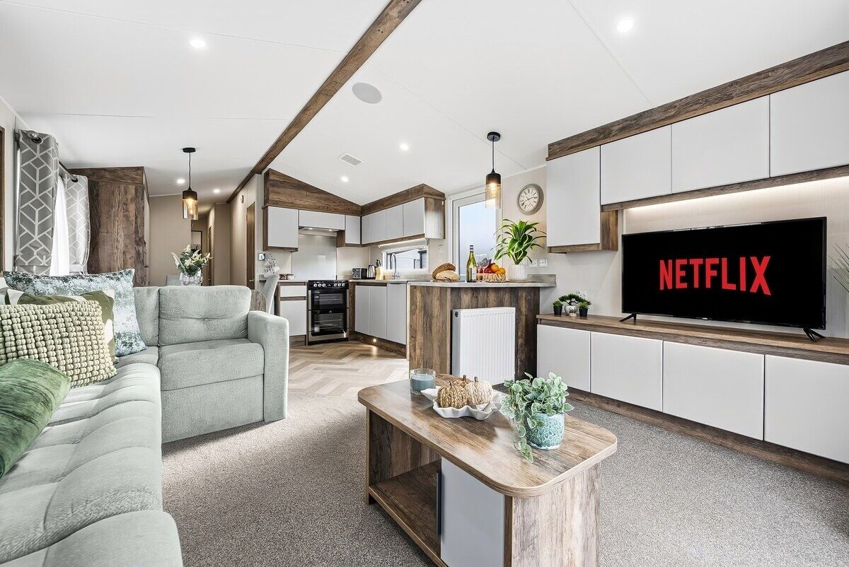 A modern living room with a sofa, coffee table, and a TV displaying the Netflix logo.