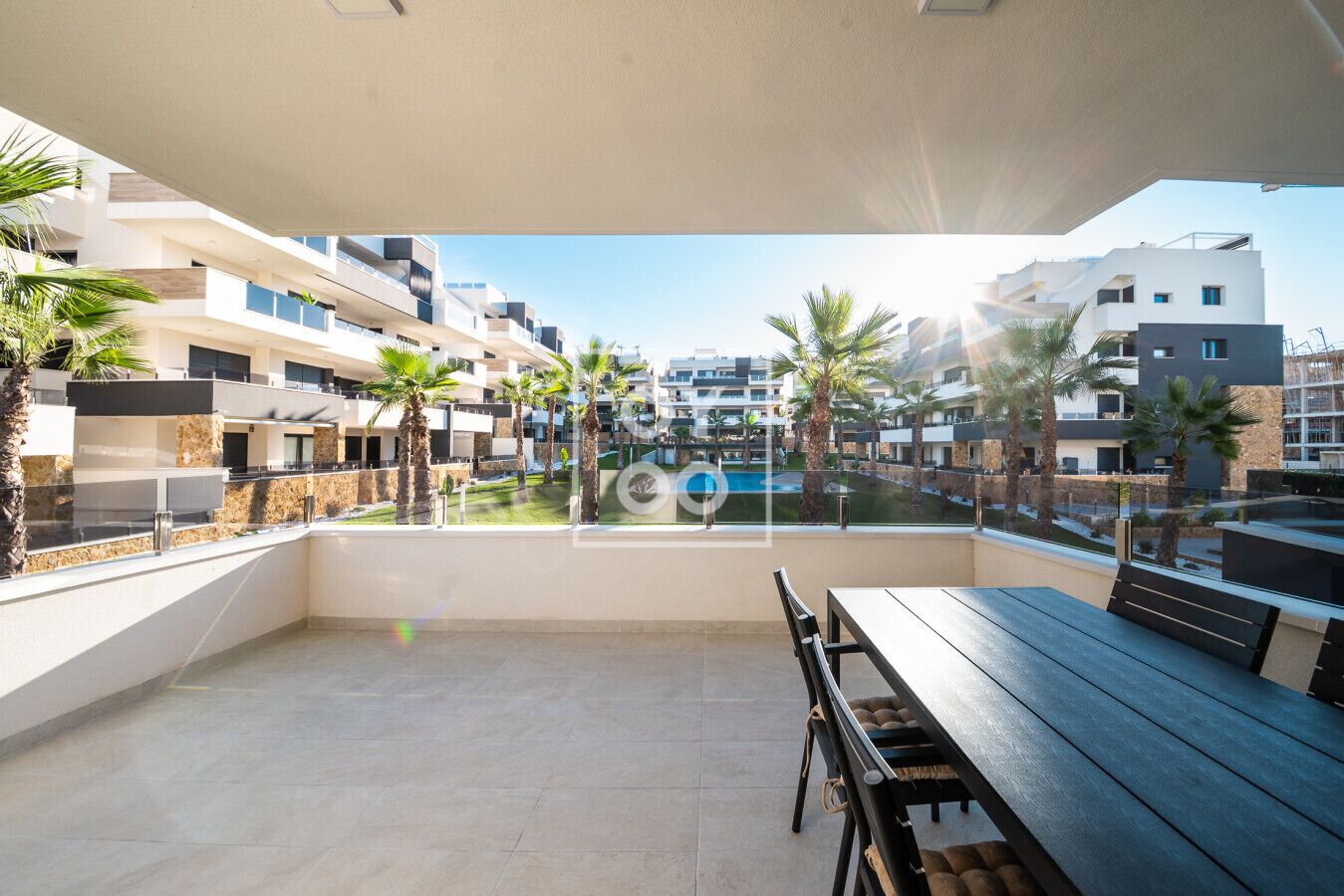 Eine moderne Außenpatio mit Blick auf einen Pool und angrenzende Gebäude.