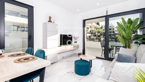 En moderne stue med spiseplads, sofa og balkon med udsigt.