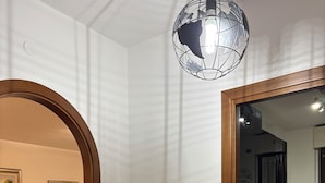 A room with a wooden-framed door leading to a kitchen area. - Marci's House (Rome)