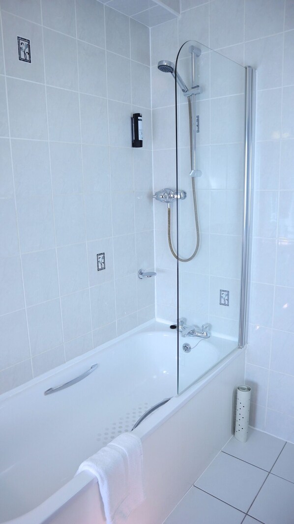 A modern bathroom with a glass-enclosed shower, a white bathtub, and a handheld showerhead. - Centennial Hotel (Cambridge)