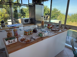 Ein Frühstücksbuffet mit verschiedenen Speisen und Blick ins Freie.