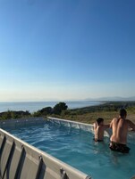 Una piscina al aire libre de temporada, sillones reclinables de piscina