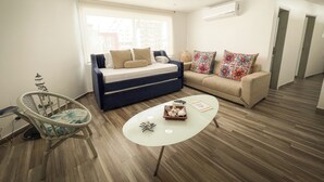 Ein modernes Wohnzimmer mit einer Couch, einem Couchtisch und einem Sessel.