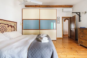 A hotel room with a bed, a wardrobe, a dresser, and a ceiling fan. - San Pier Maggiore - One Bedroom Apartment, Sleeps 2 (Firenze)