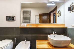 A modern bathroom with a large mirror, a wooden vanity, a white sink, and a bidet. - San Pier Maggiore - One Bedroom Apartment, Sleeps 2 (Firenze)