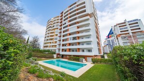 A multi-story residential building with balconies, a swimming pool, and a well-maintained garden. - Studio Aqua with Shared Pool, WiFi and Air Conditioning (Portimão)