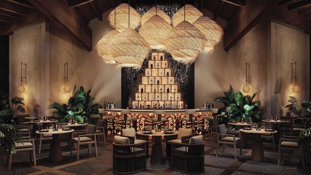 A bar area with a central display of bottles, surrounded by seating and decorative lighting. - Lopesan Serenity Bay Resort, Spa & Casino – Adults Only All-Inclusive (Punta Cana)
