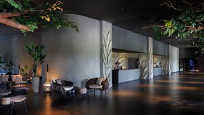 A modern lobby with seating, a reception desk, and indoor plants. - Lopesan Serenity Bay Resort, Spa & Casino – Adults Only All-Inclusive (Punta Cana)