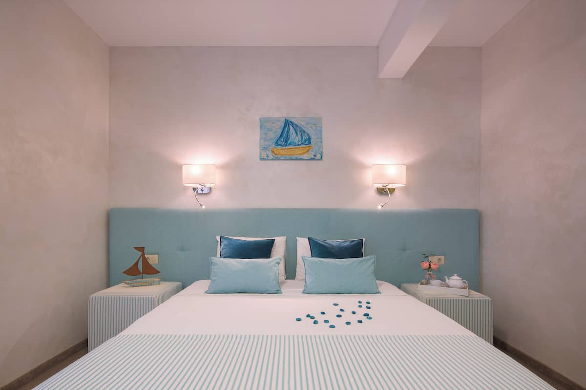 A neatly arranged hotel room with a large bed, two bedside tables, a headboard, and a wall-mounted painting.