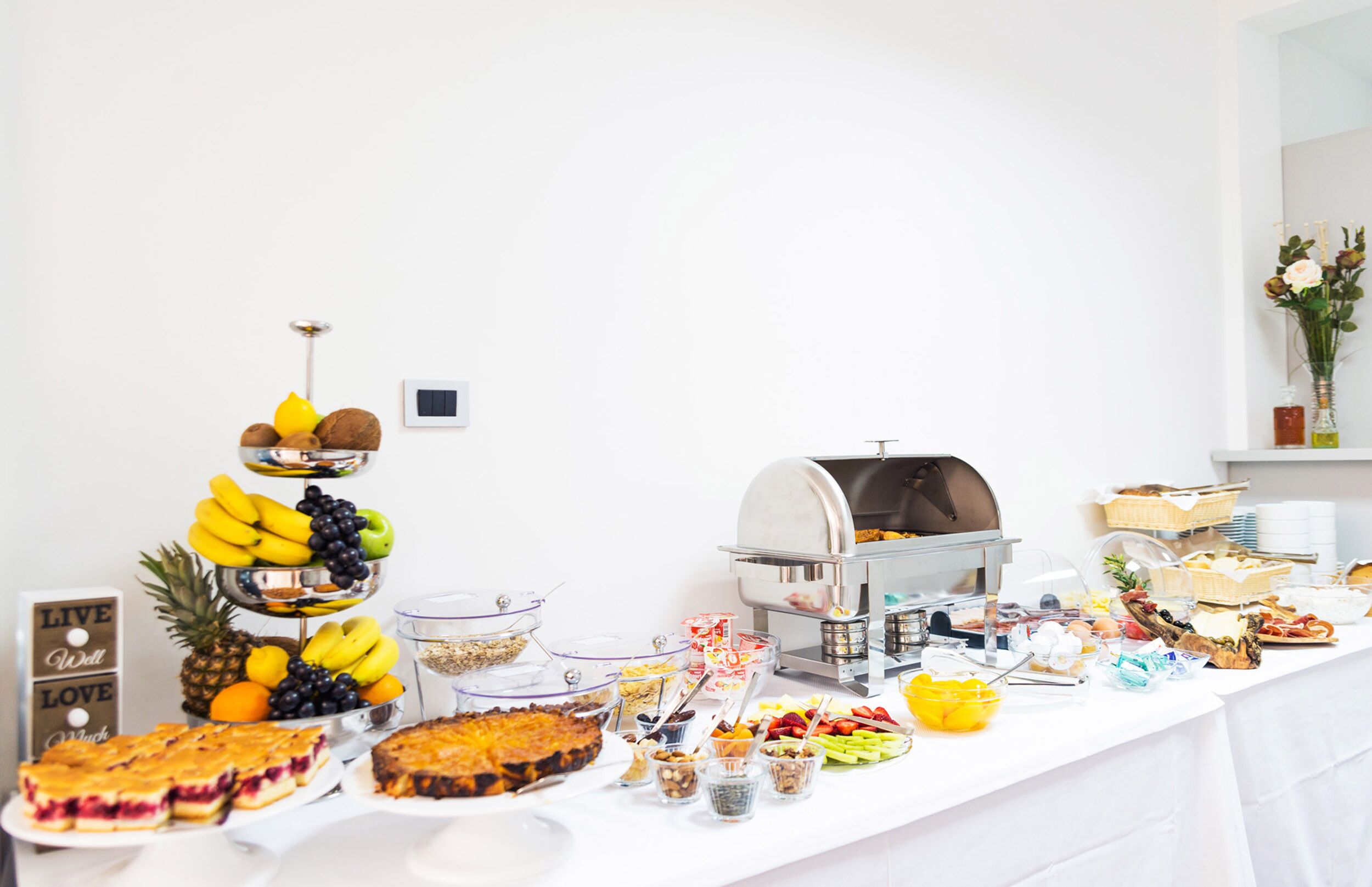 Une table de buffet proposant divers plats et un coin café.