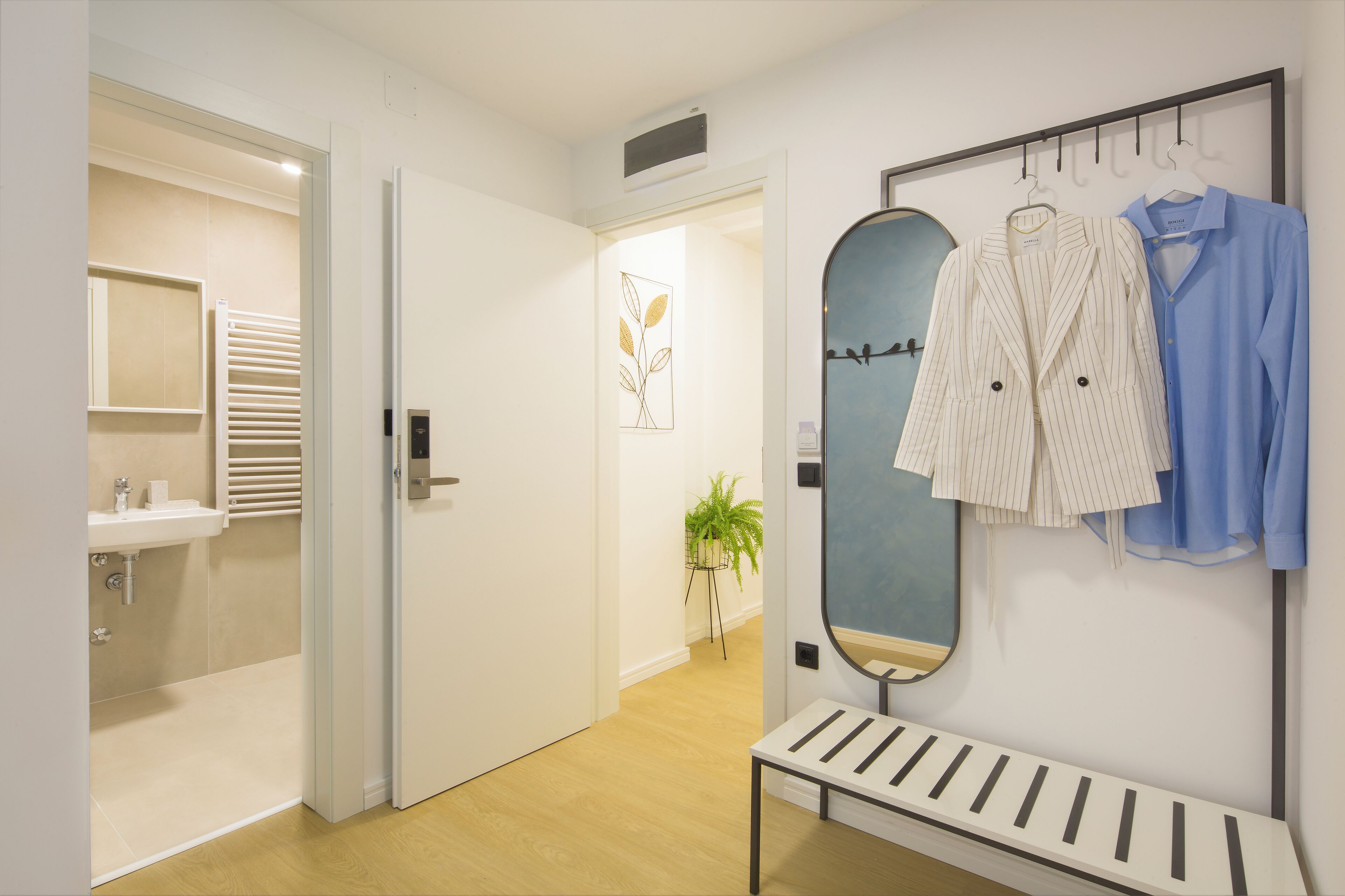 A modern bathroom with a sink, towel rack, and a mirror.