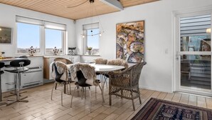 Cozinha moderna com área de jantar, com uma grande janela, mesa e cadeiras, e vista para o exterior.