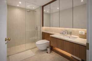 Ein modernes Badezimmer mit einer Duschkabine aus Glas, einer weißen Toilette und einem Holzbadezimmer mit Waschbecken.
