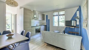Een moderne keuken met een eethoek, een bank en een aan de muur bevestigde televisie.