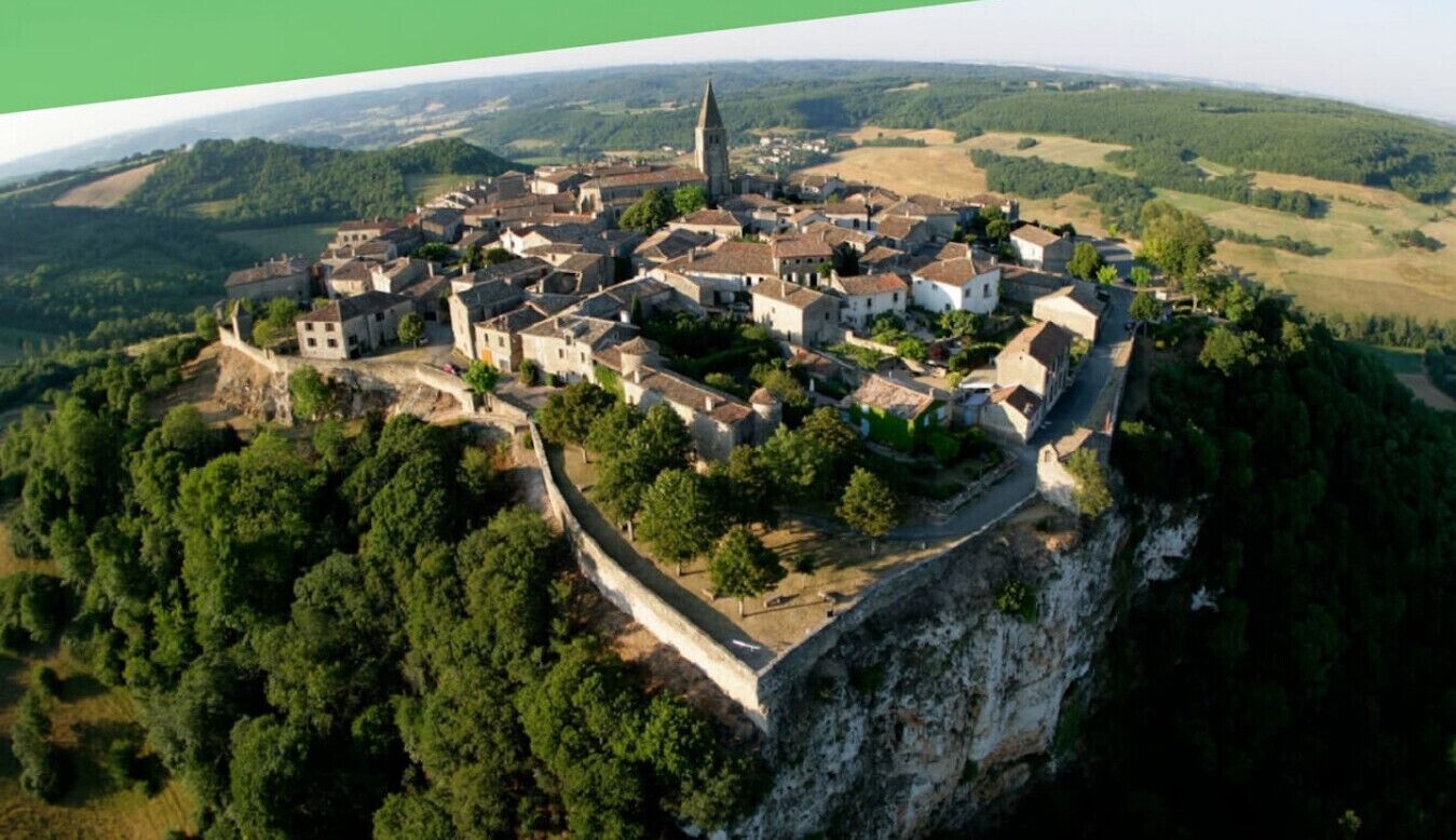 A medieval town with a prominent church and castle perched on a cliff.