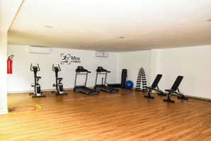 A gym with cardio machines, weightlifting equipment, and a blue exercise ball. - Flat Le Jamalu Praia de Carneiros, 400m from the sea and close to Acquaventura Park. (Tamandaré)