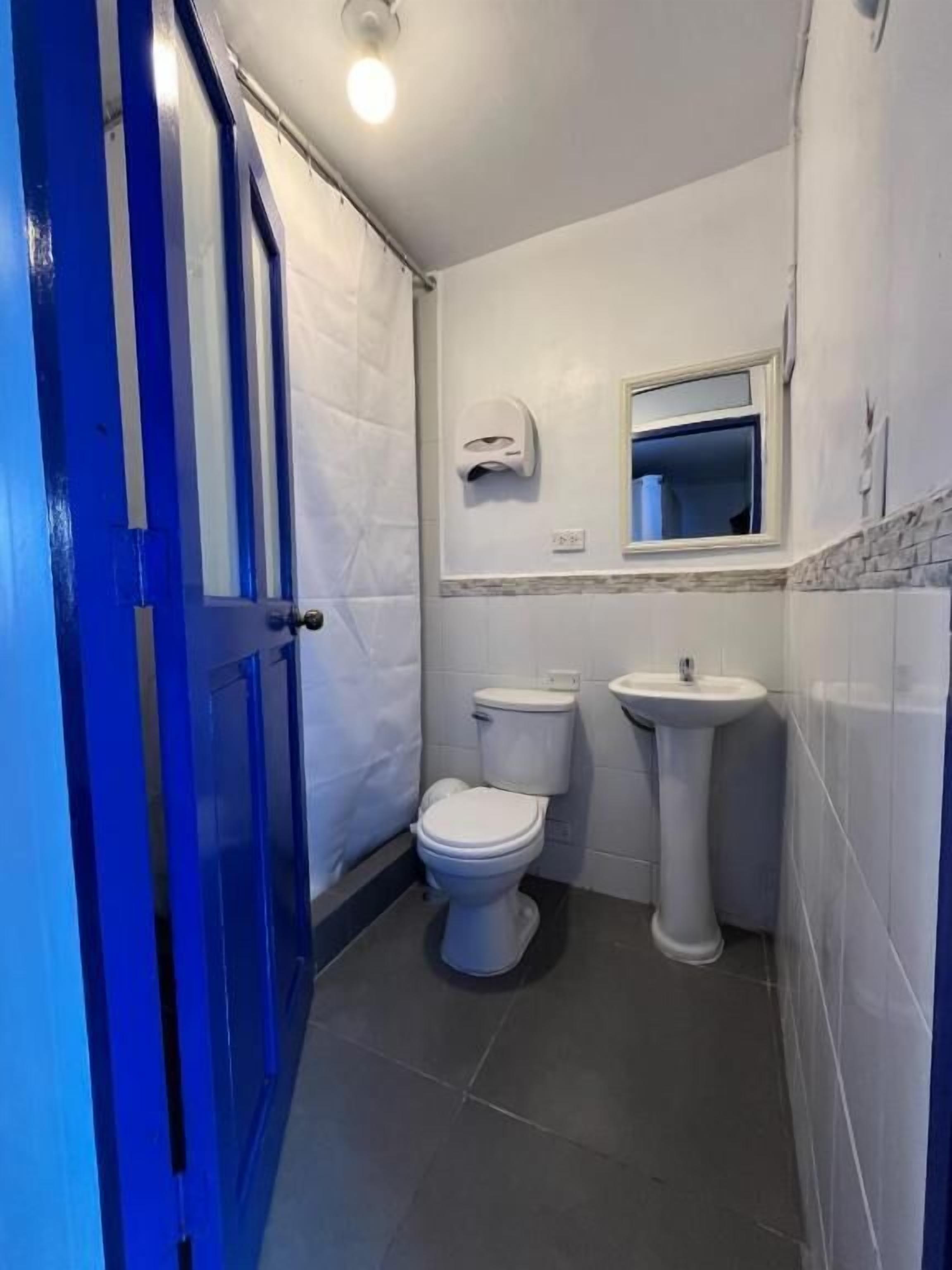 A small bathroom with a toilet, sink, and a mirror above the sink.