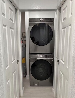 A laundry room with two stacked Samsung washing machines. - The St. Pete Beach Home (Saint Petersburg)