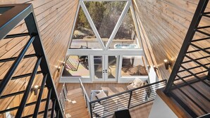 Eine moderne Holz-Blockhütte mit Glasdach, Whirlpool und Blick auf den umliegenden Wald.