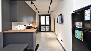 A modern kitchen with a wooden countertop, a black refrigerator, and a TV mounted on the wall. - Cozy 1-bedroom apartment in adorable Yerevan with AC and Balcony (Yerevan)