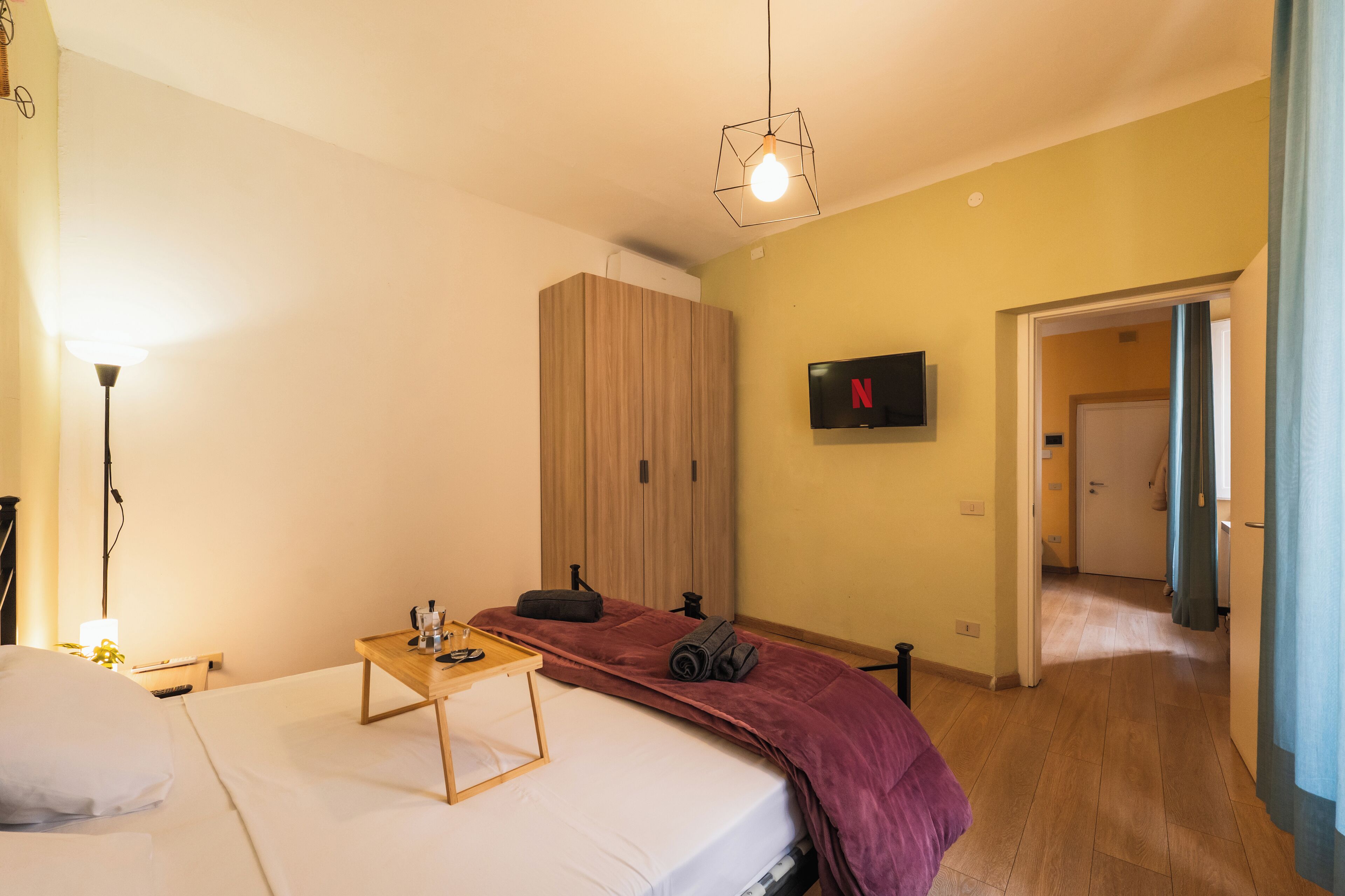 Une chambre d’hôtel équipée d’un lit, d’un bureau, d’une armoire et d’un téléviseur affichant le logo de Netflix.