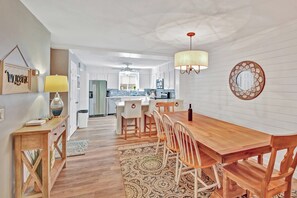 A modern kitchen with white cabinets, a wooden dining table, and a patterned rug. - 4 bedroom - 4.5 bath condo.  With Ocean views. (Saint Simons Island)