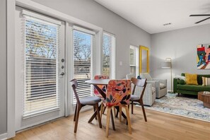 A dining area with a round table and chairs, a sofa, and a colorful rug. - Exceptional 2BR in Prime Location Top Amenities (Austin)