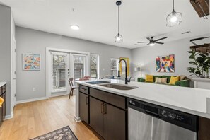 A modern kitchen with a central island, built-in dishwasher, and a ceiling fan. - Exceptional 2BR in Prime Location Top Amenities (Austin)