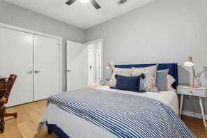 A bedroom with a bed, bedside tables, a desk, and a wardrobe. - Exceptional 2BR in Prime Location Top Amenities (Austin)