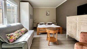 Ein Schlafzimmer mit Bett, Nachttisch, Kleiderschrank und Fernseher.