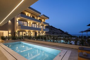A modern multi-story building with a pool and outdoor seating area. - Deluxe Villa Celeste - Sea View and Private Pool (Mylopotamos)