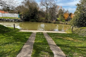 A pathway leading to a pond surrounded by grass and trees. - La Maison du Bonheur - Your haven of peace with pool and garden (Le Gué-de-Velluire)
