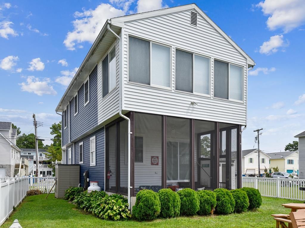 A two-story house with a covered porch and a fenced yard.