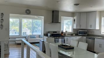 A modern kitchen with white cabinets, a dining table, and chairs.