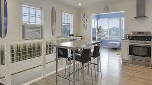 A modern kitchen with a central island, stainless steel appliances, and large windows. - 4BR Home Near the Beach! | Canal Access + Porch (South Bethany)