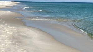 Ein Strand mit klarem, blauem Wasser und einem sandigen Ufer.