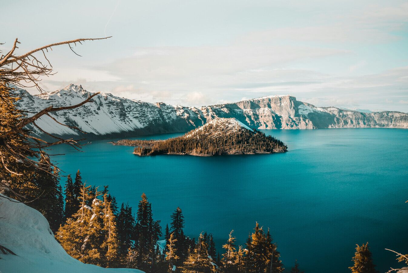 A mountainous landscape with a lake and a snow-covered island.